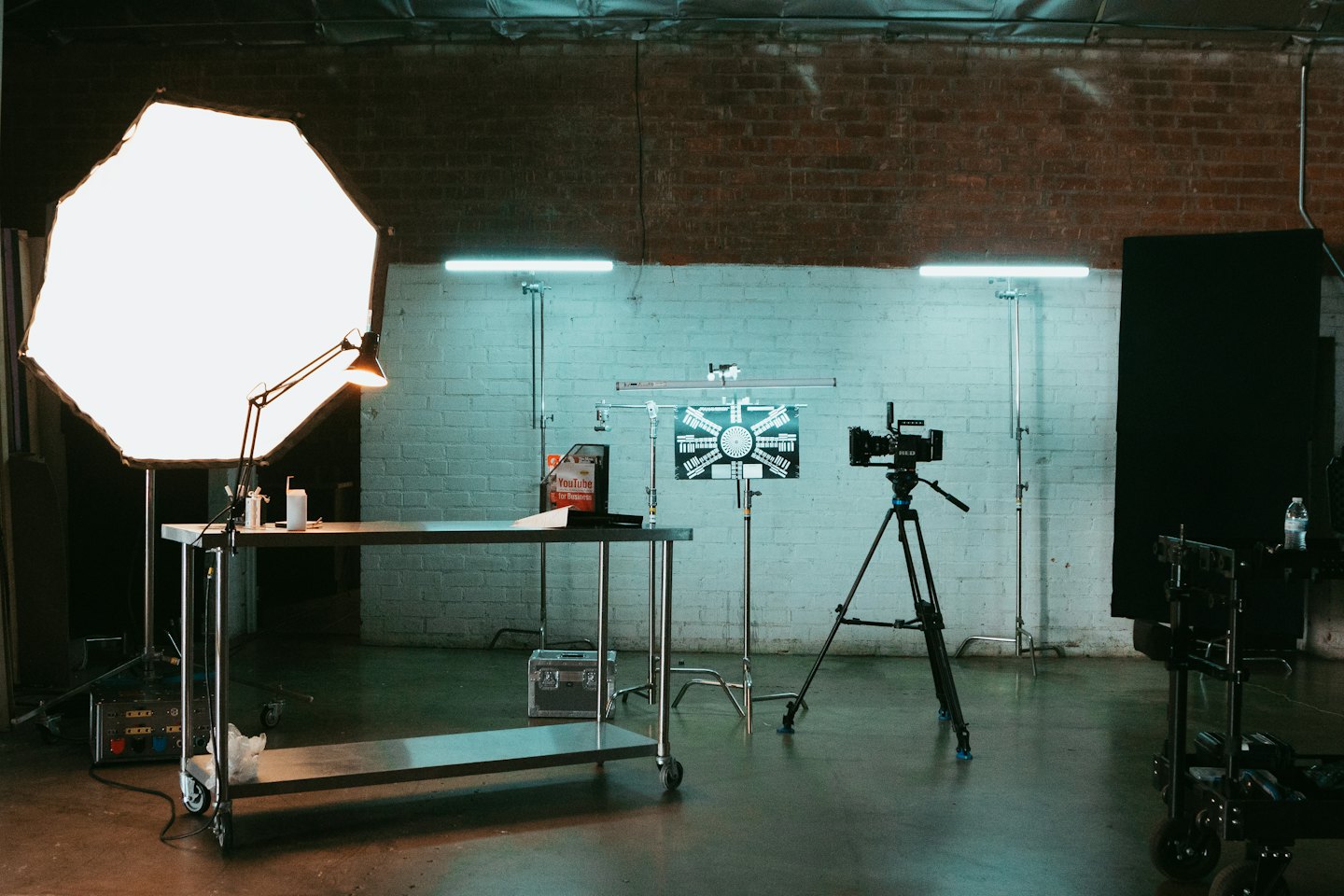 Cinema camera on tripod facing calibration chart in studio.