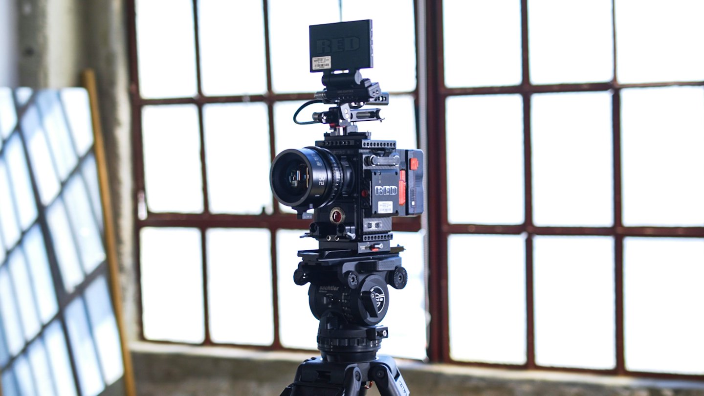 Professional cinema camera with monitor on tripod indoors.