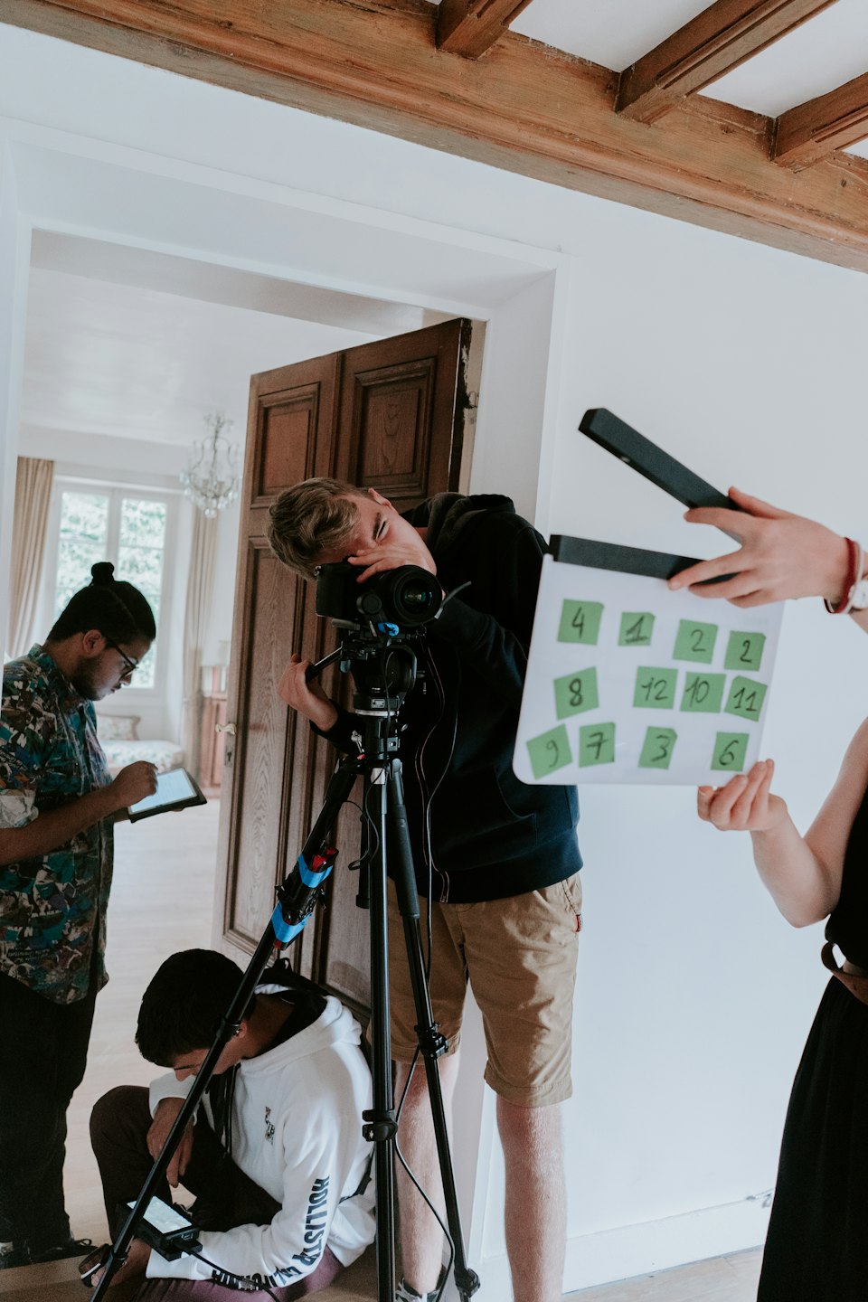 Film crew works together on a movie set indoors.