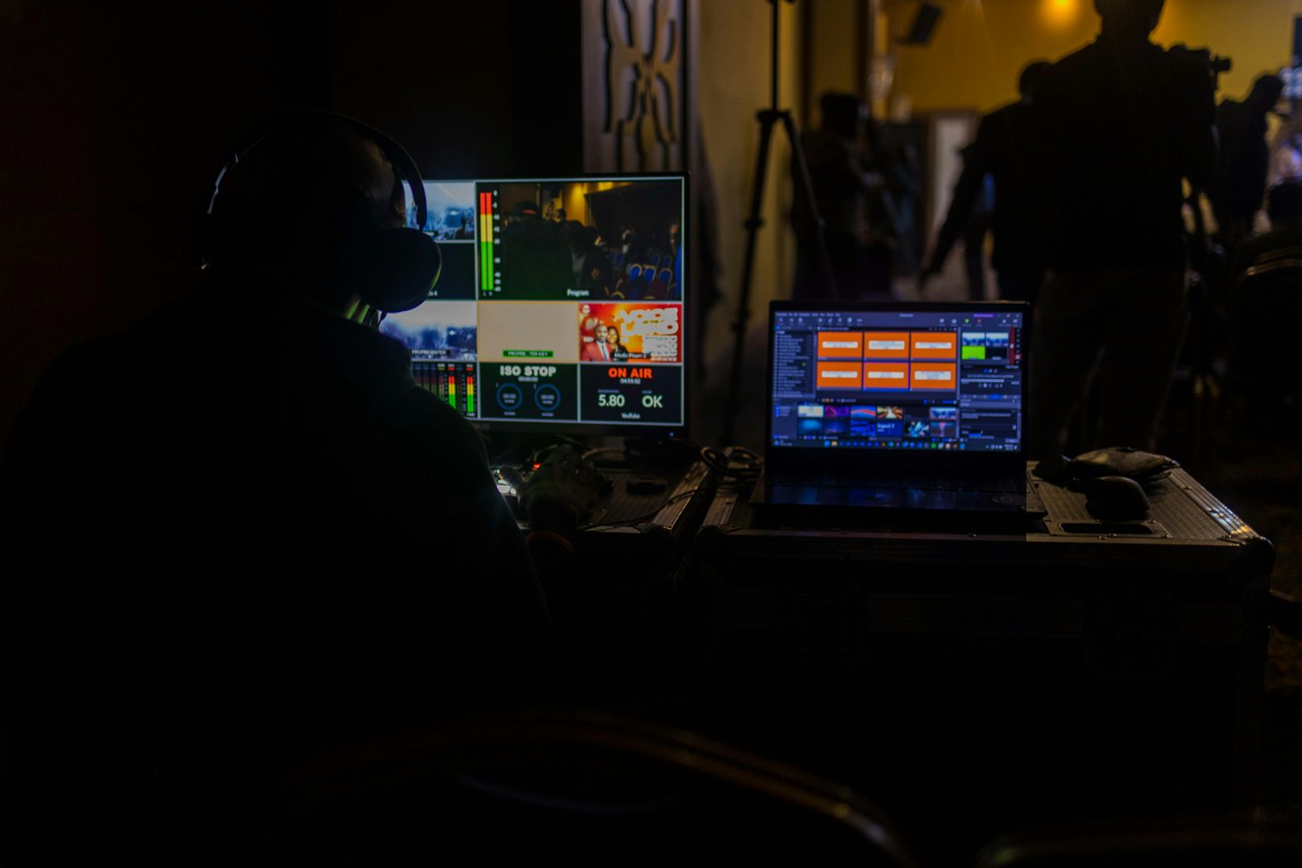Person with headphones operates video production monitors.